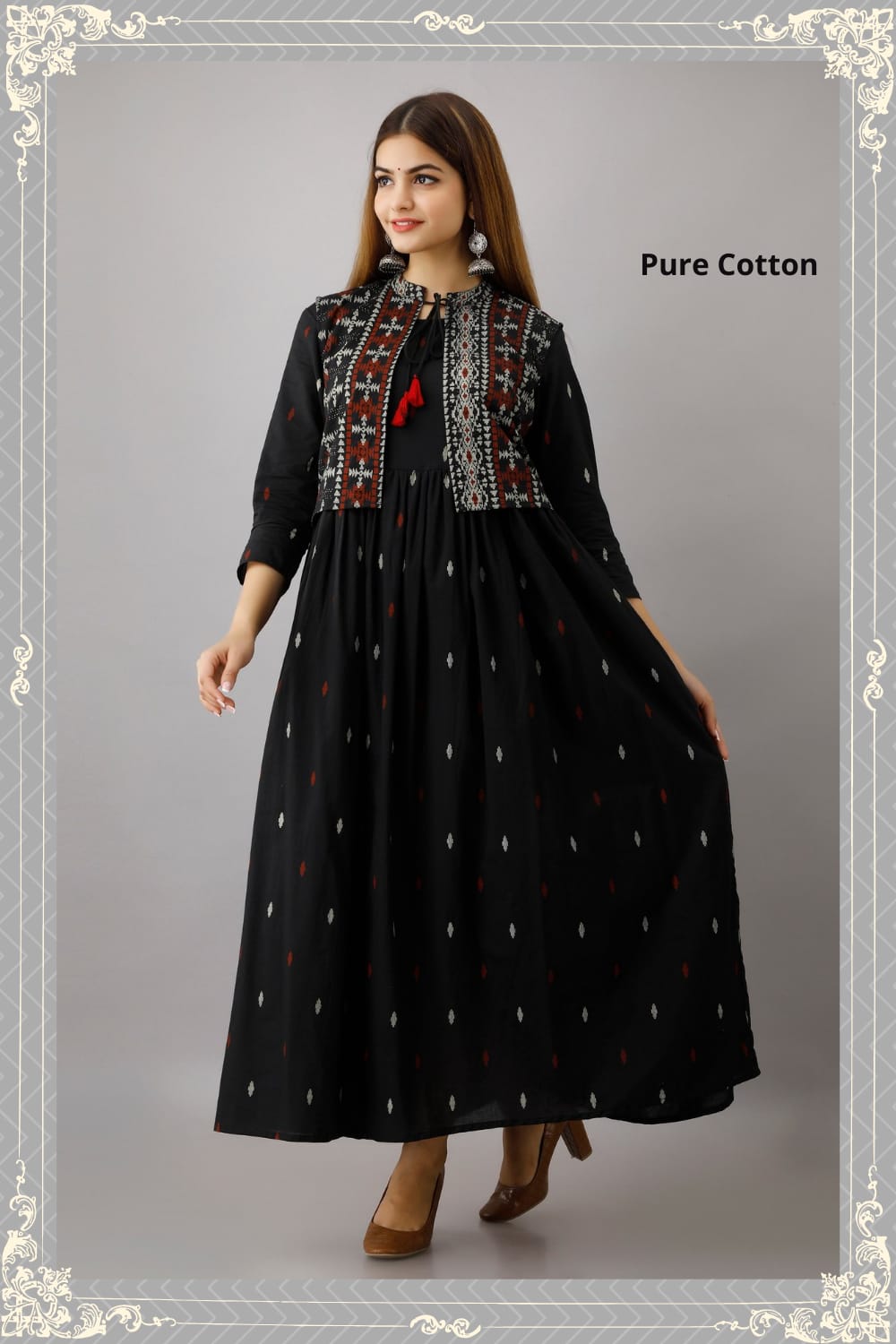 A woman posing in a long black gown with a geometric pattern and a black jacket with red accents and pure cotton text label.
